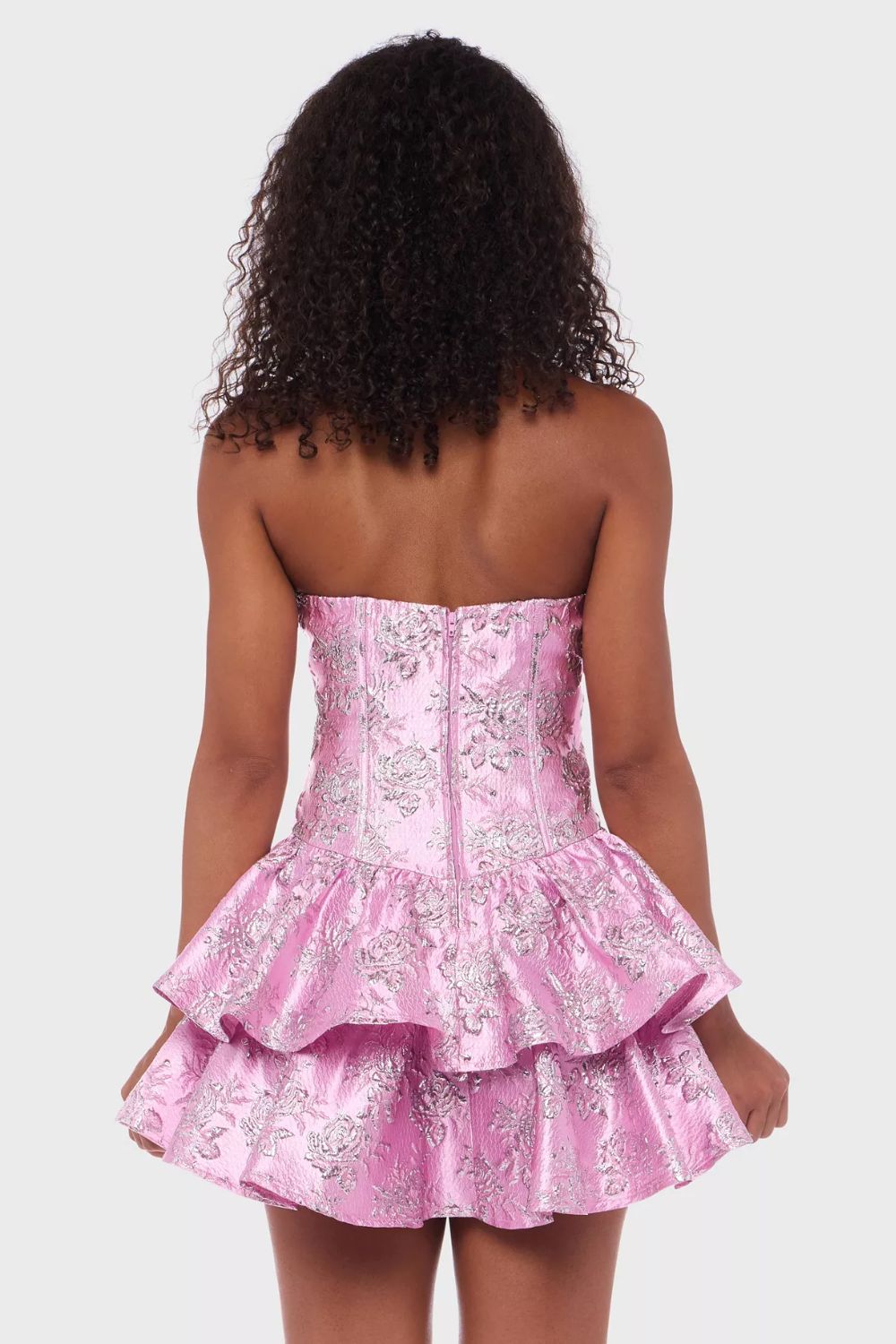 Vestido corto strapless rosa con textura floral y caida estructurada en capas